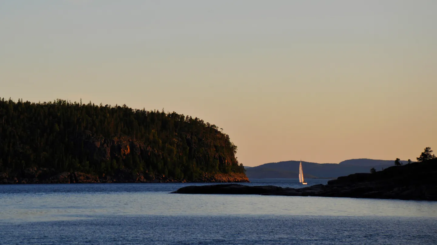 Skrubban och segelbåt på havet