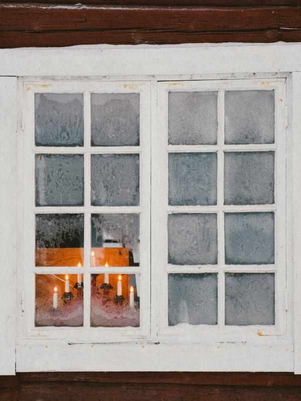vitt fönster med adventsljusstake