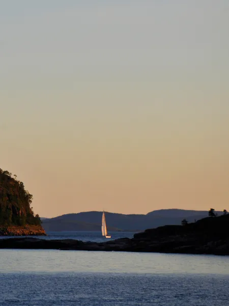 Skrubban och segelbåt på havet